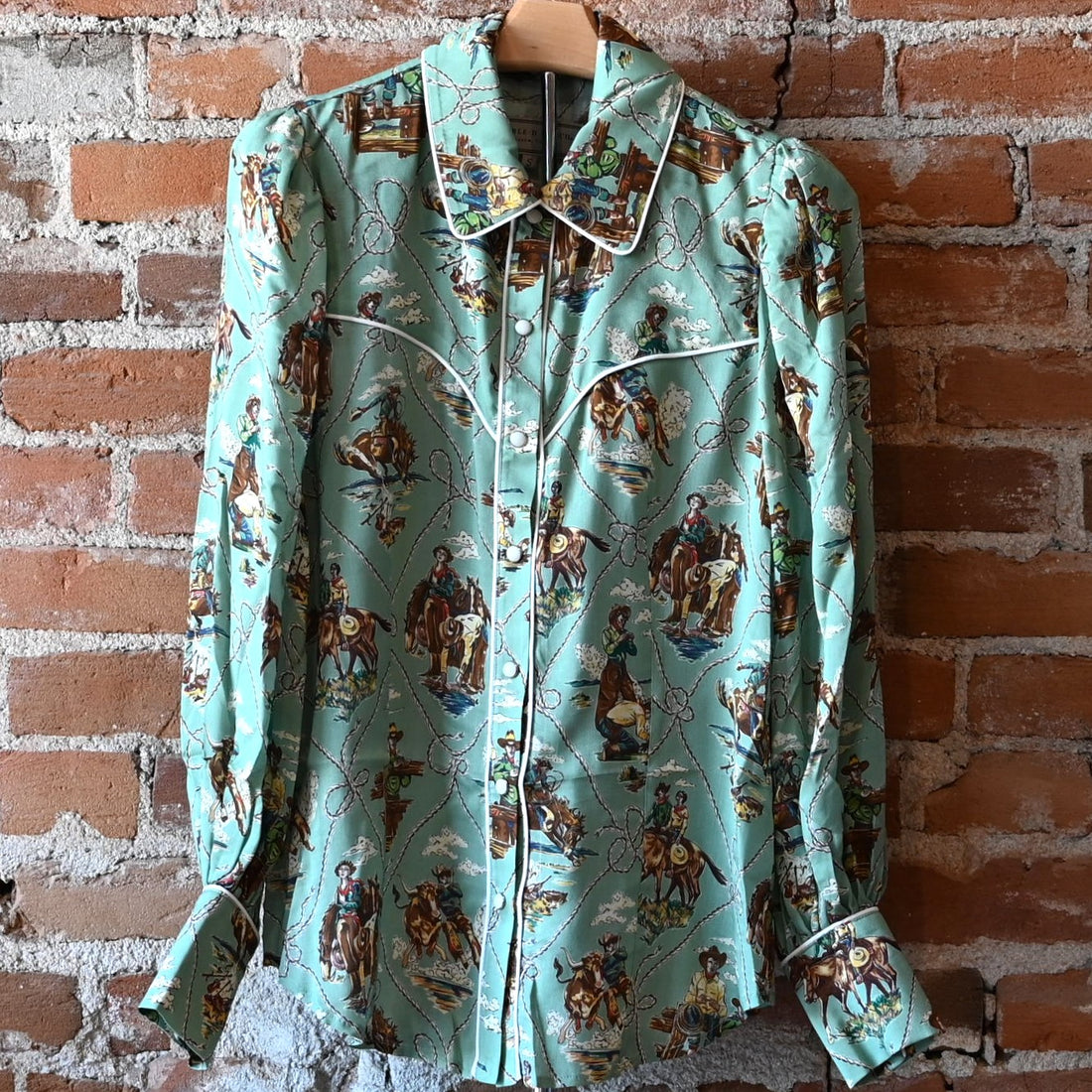 Ladies Romance &amp; Rustlers Top by Double D Ranch with mint-green pulp-art print, pearl snaps, contrast piping, and full cuffed sleeves