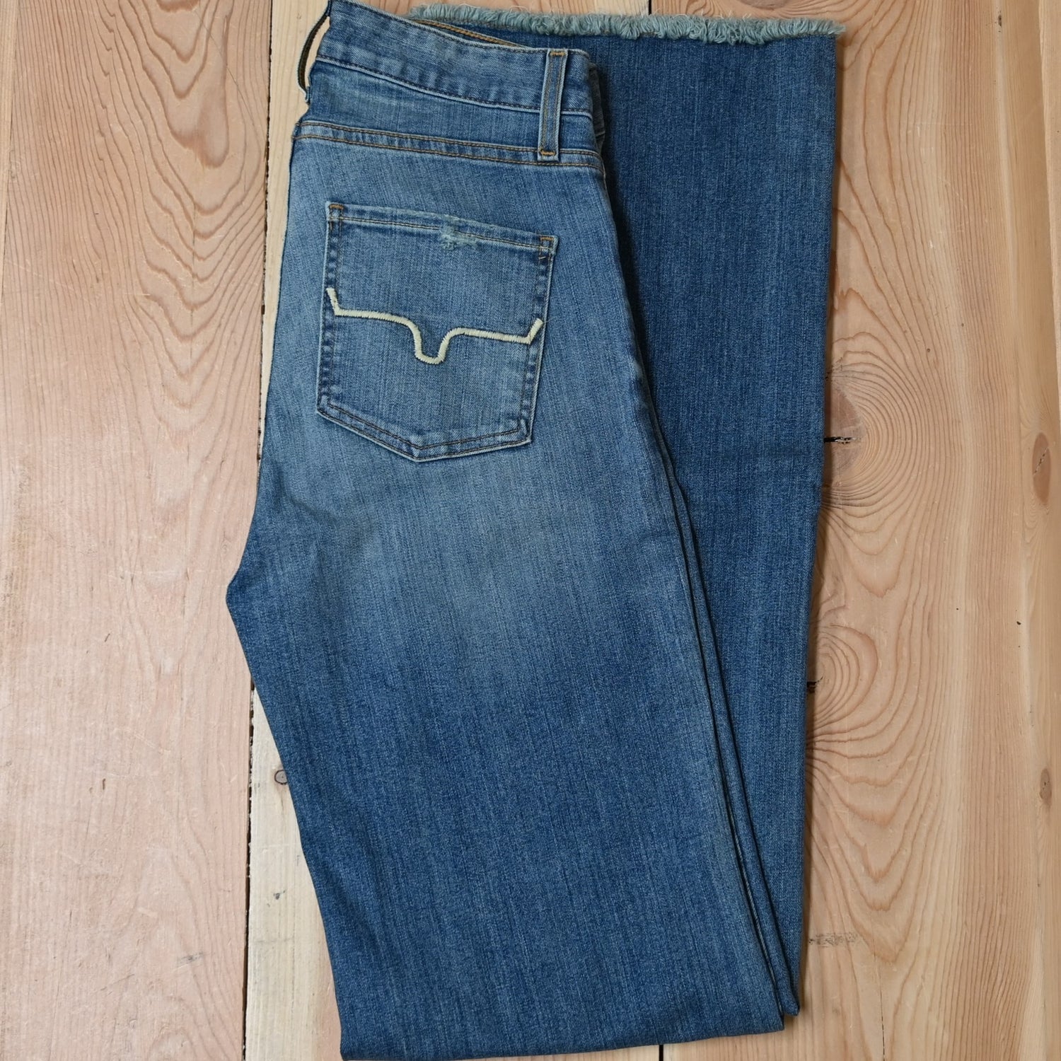 View of Kimes Ranch Olivia Trouser in Light Wash featuring whisker details with a high-rise, wide-leg cut and raw hem