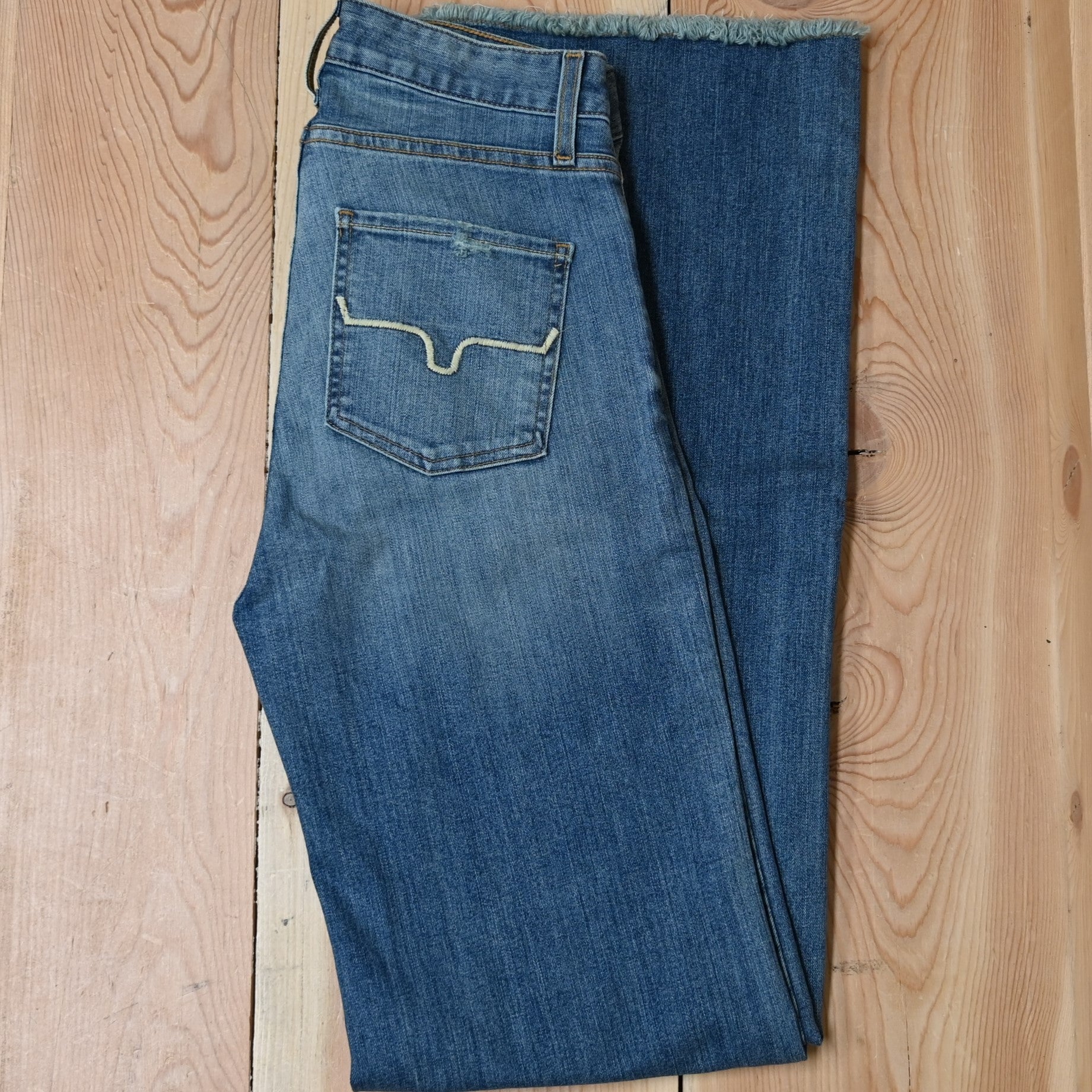 View of Kimes Ranch Olivia Trouser in Light Wash featuring whisker details with a high-rise, wide-leg cut and raw hem