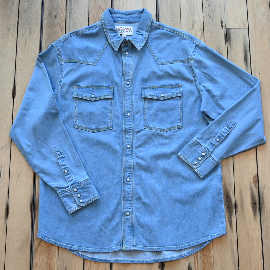 View of Schaefer denim snap shirt in dark indigo, gray, and light indigo with Western yokes and chest pockets
