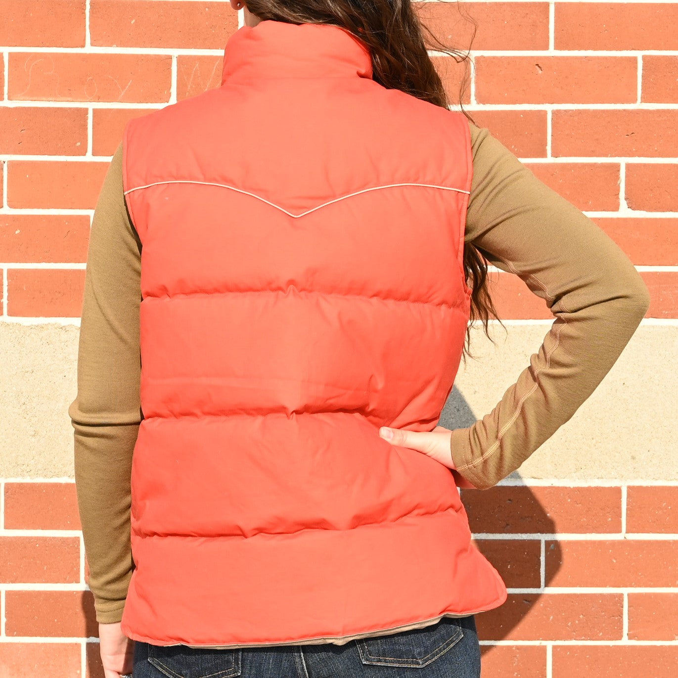 View of Filson Ladies Waxed Down Vest in Campfire featuring curved shoulder yokes and fleece-lined hand pockets