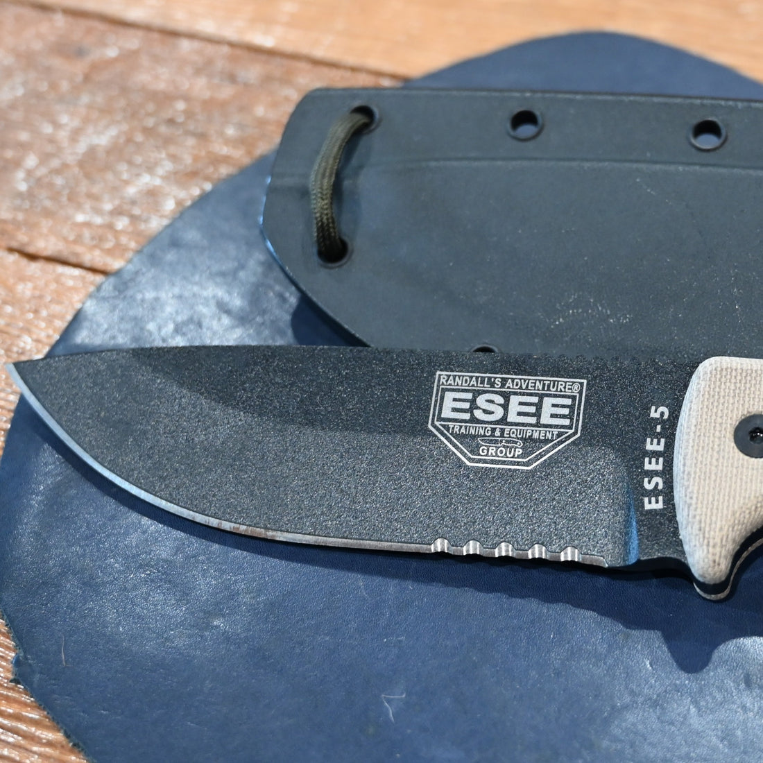 ESEE-5 serrated edge fixed blade knife with black coated blade, micarta handle, and MOLLE sheath