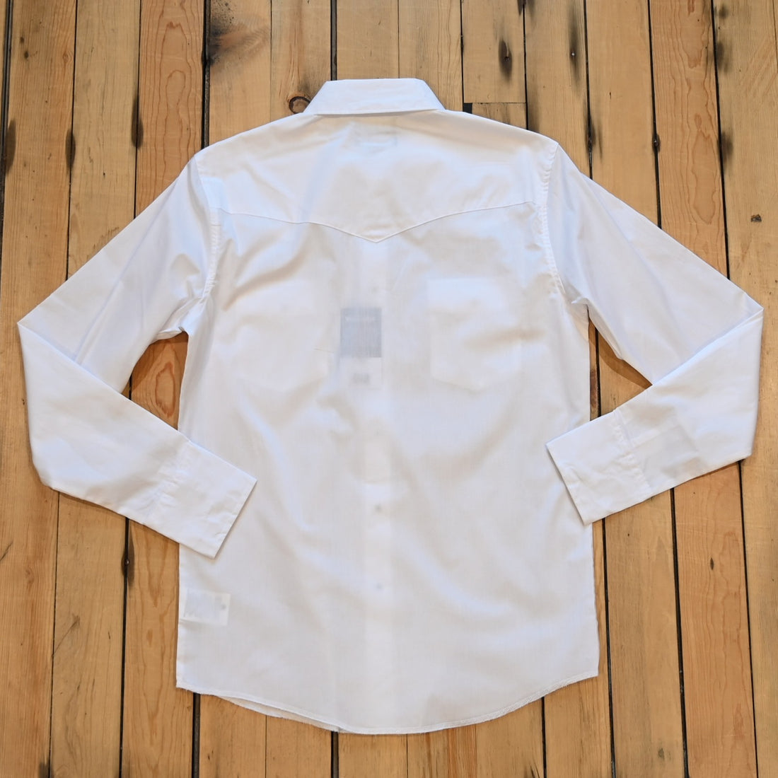View of Wrangler men’s white Western snap shirt in broadcloth with yokes and flap pockets