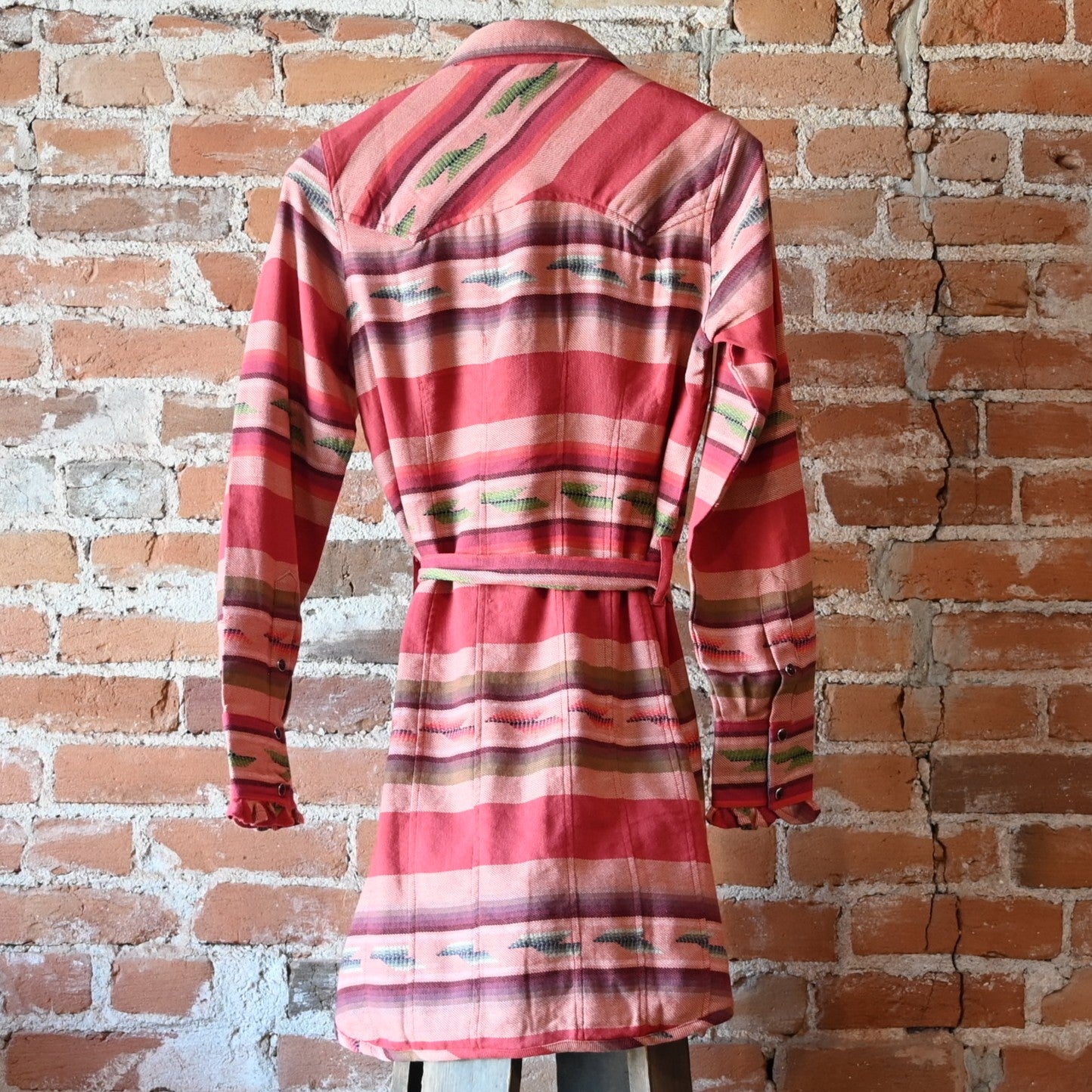 Ladies Colt 44 Tunic in rouge serape pattern with pearl snaps, self-tie belt, collar, and double breast pockets