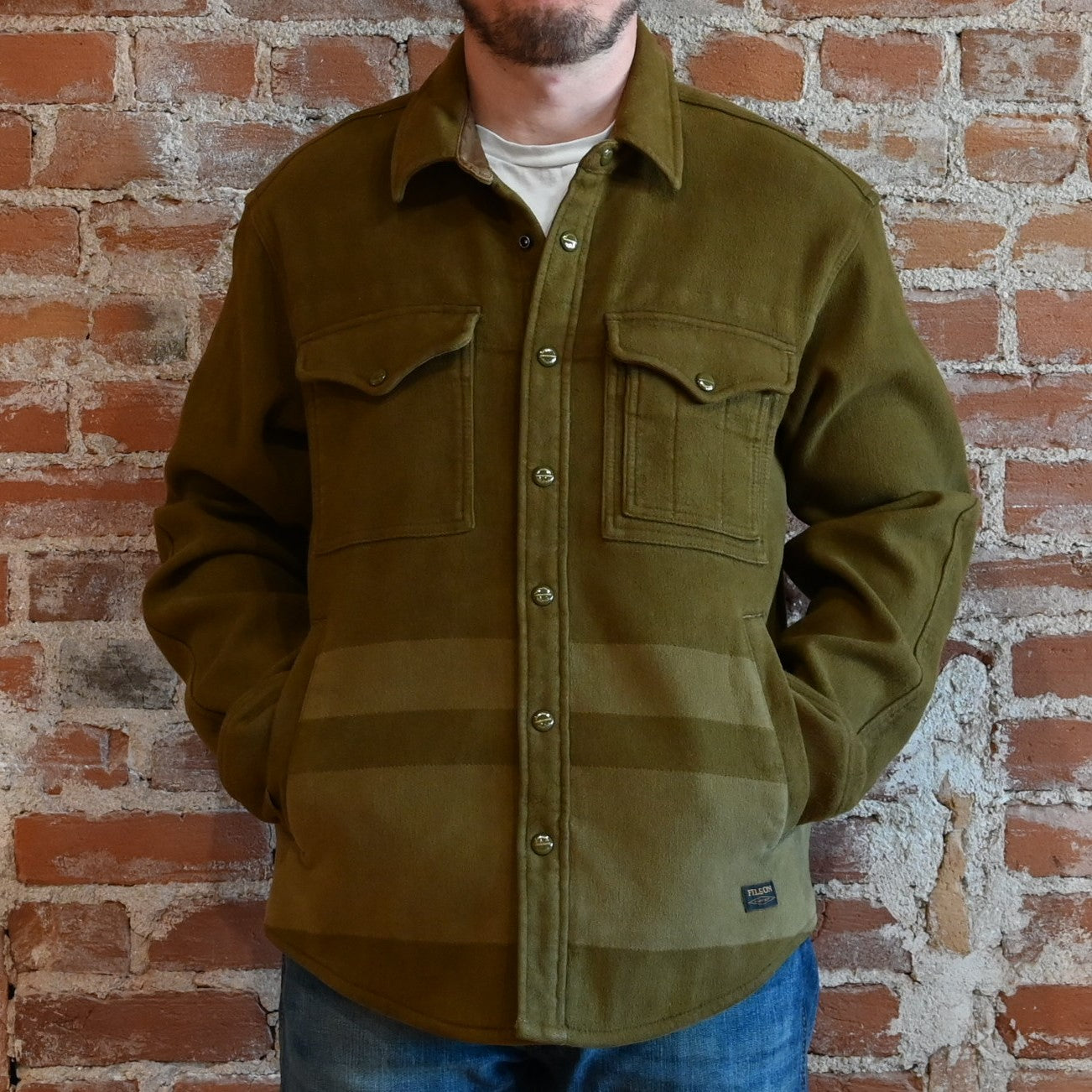 View of Filson Beartooth Jac-Shirt in Marsh Olive Stripe featuring snap-flap chest pockets and reinforced forearms