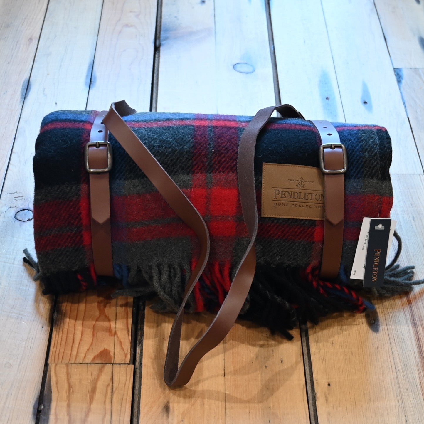 View of Pendleton Brookings Plaid motor robe throw in black, red, and grey with leather carrier
