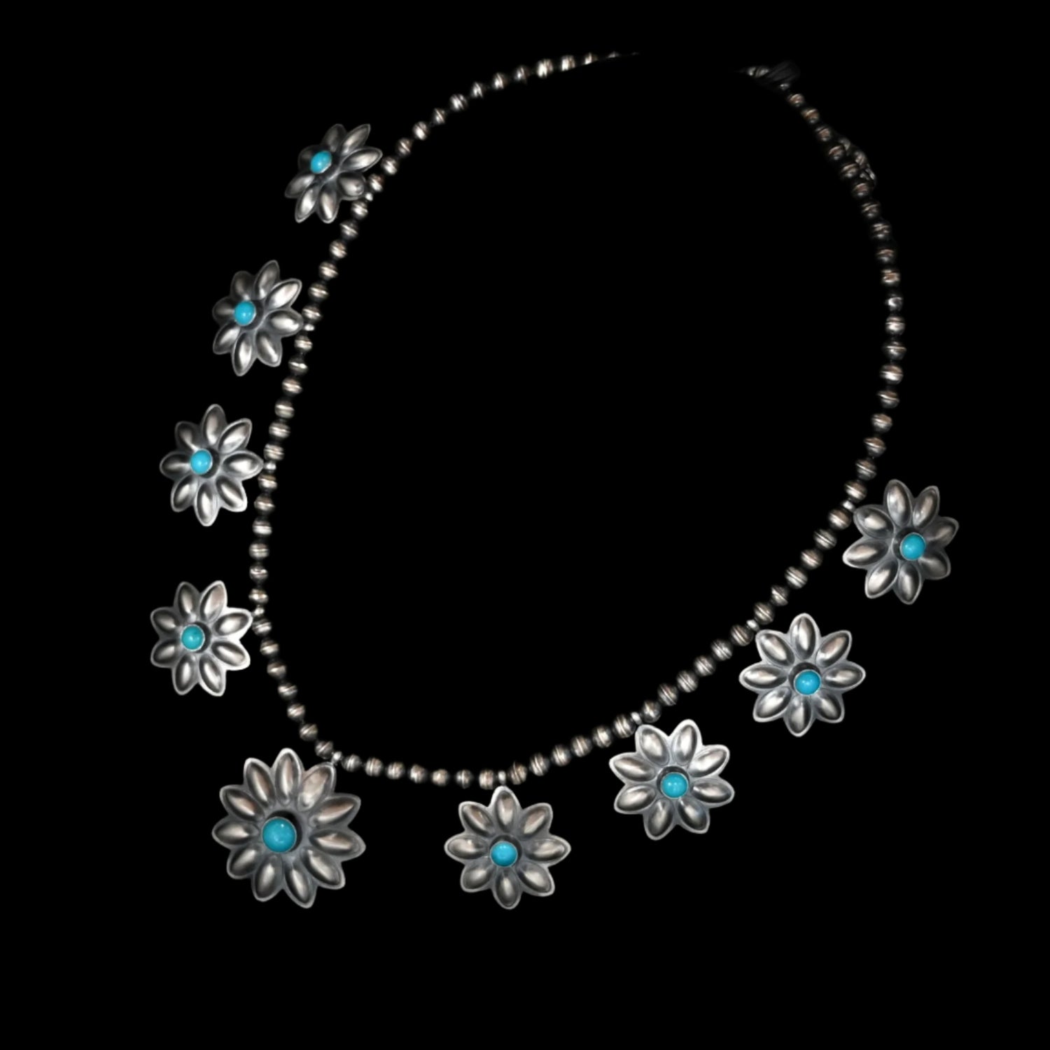 View of Robert Johnson Turquoise Stone Flower Necklace featuring nine sterling silver flowers with turquoise stones at the center