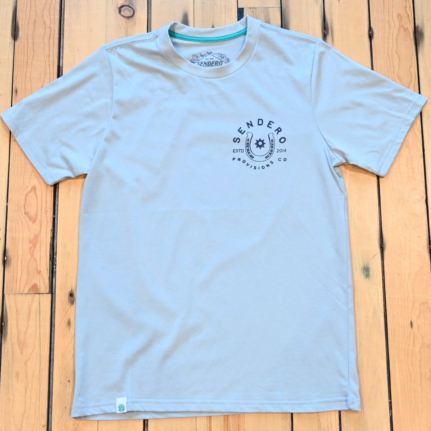 Big Sky Blue No Luck T-Shirt by Sendero with bucking horse graphic and “Luck’s Got Nothin’ to Do With It” text