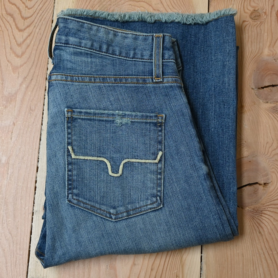 View of Kimes Ranch Olivia Trouser in Light Wash featuring whisker details with a high-rise, wide-leg cut and raw hem