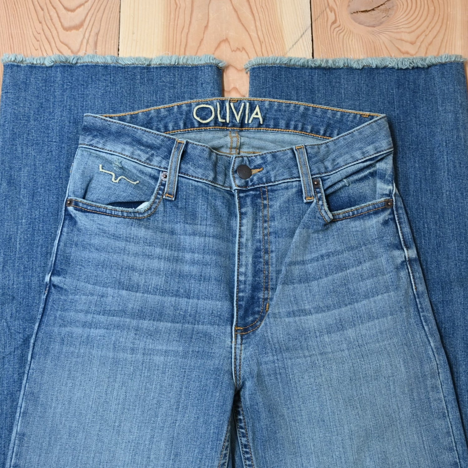 View of Kimes Ranch Olivia Trouser in Light Wash featuring whisker details with a high-rise, wide-leg cut and raw hem