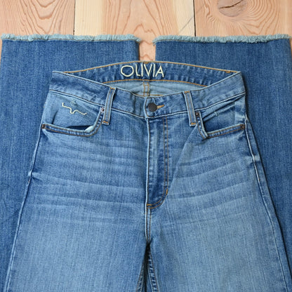 View of Kimes Ranch Olivia Trouser in Light Wash featuring whisker details with a high-rise, wide-leg cut and raw hem