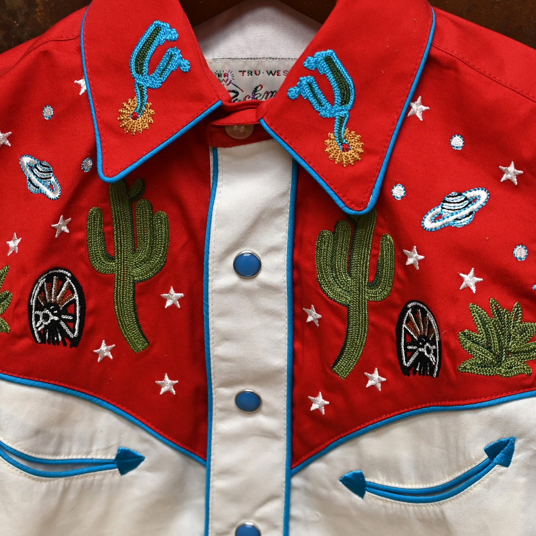View of Red and ivory youth Western shirt with cactus and star embroidery and snap details