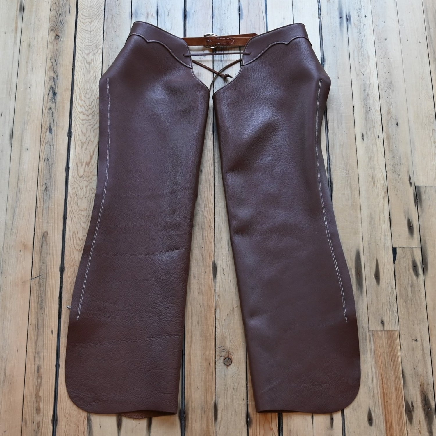 View of Weaver Shotgun Full Grain Chaps in brown oil-tanned leather with adjustable closures.