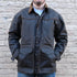 View of Oak waxed canvas RangeWax Drifter coat with leather collar, corduroy trim, pockets, and storm flap