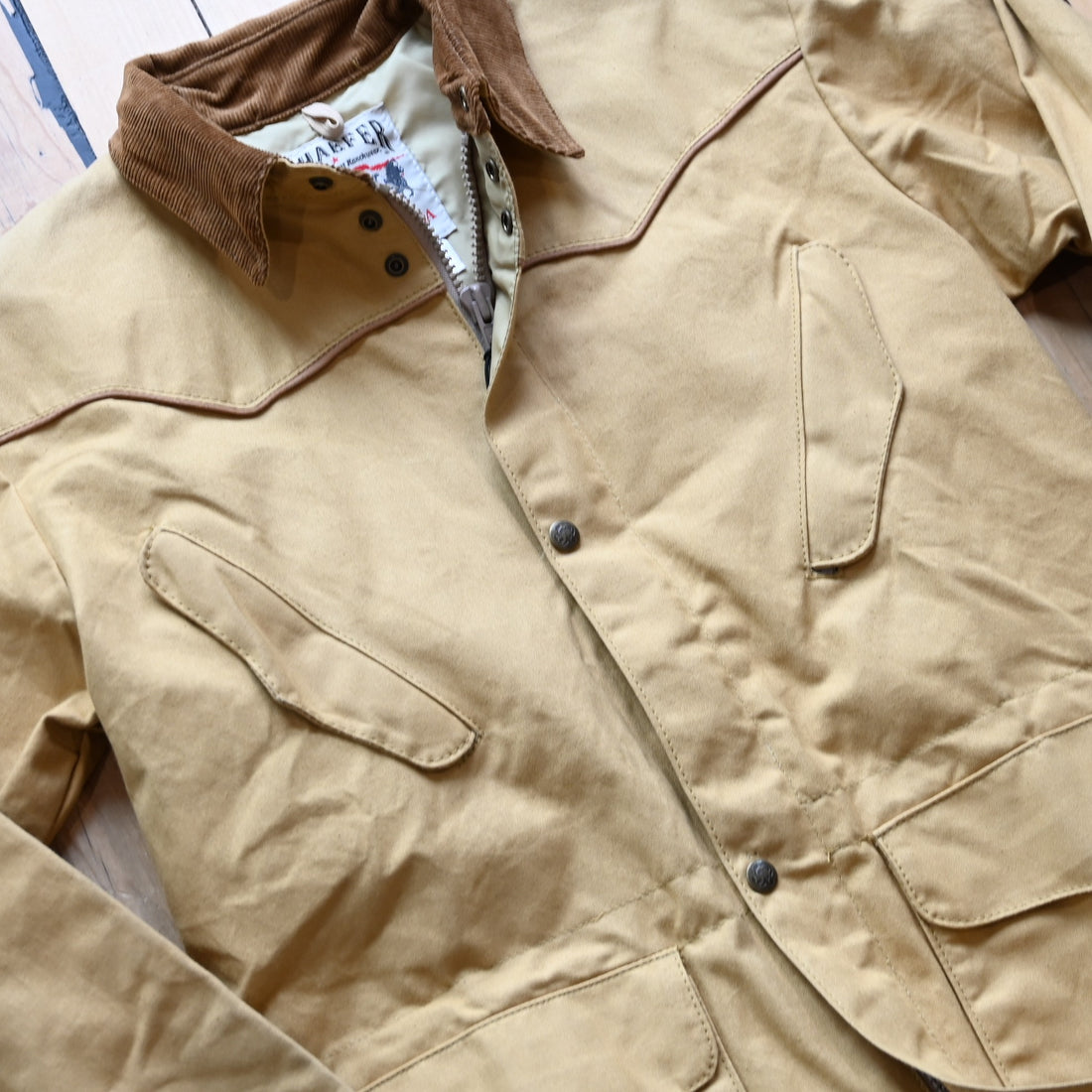 View of Schaefer canvas duster in solid suntan with corduroy collar and full-length storm flap