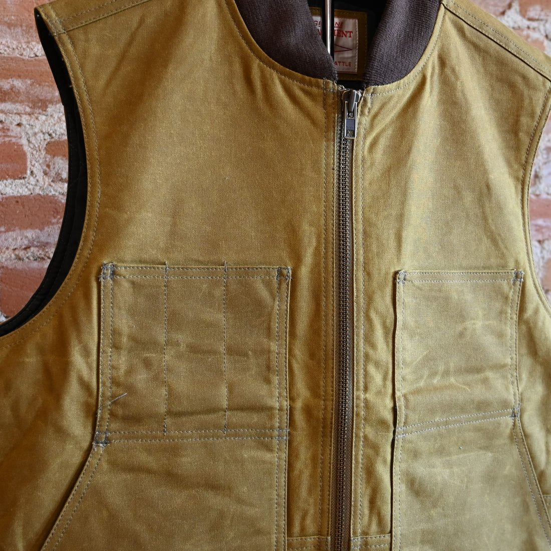View of Filson Tin Cloth Insulated Work Vest in Dark Tan, showcasing durable Tin Cloth fabric and multiple functional pockets