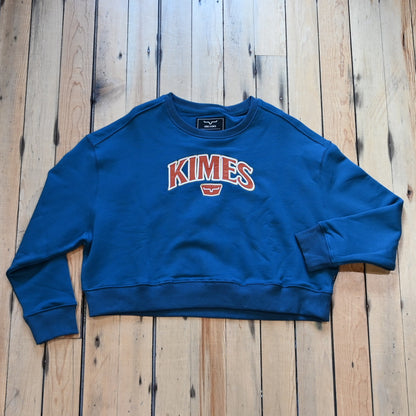 View of Kimes Ranch Ladies Colfax Crew Sweatshirt in Mid Blue, featuring an oversized fit, ribbed hem, and embroidered logo