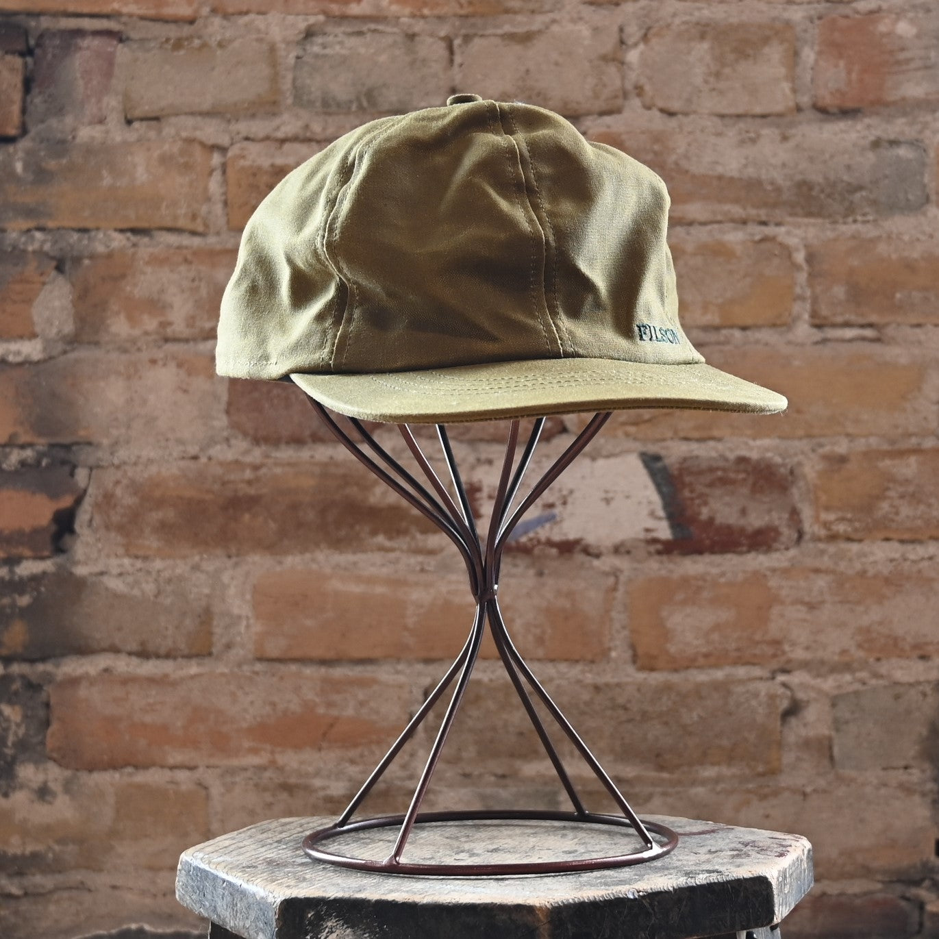 View of Filson Insulated Tin Cloth Cap in Dark Tan featuring wool ear/neck flap and 3&quot; pre-curved bill