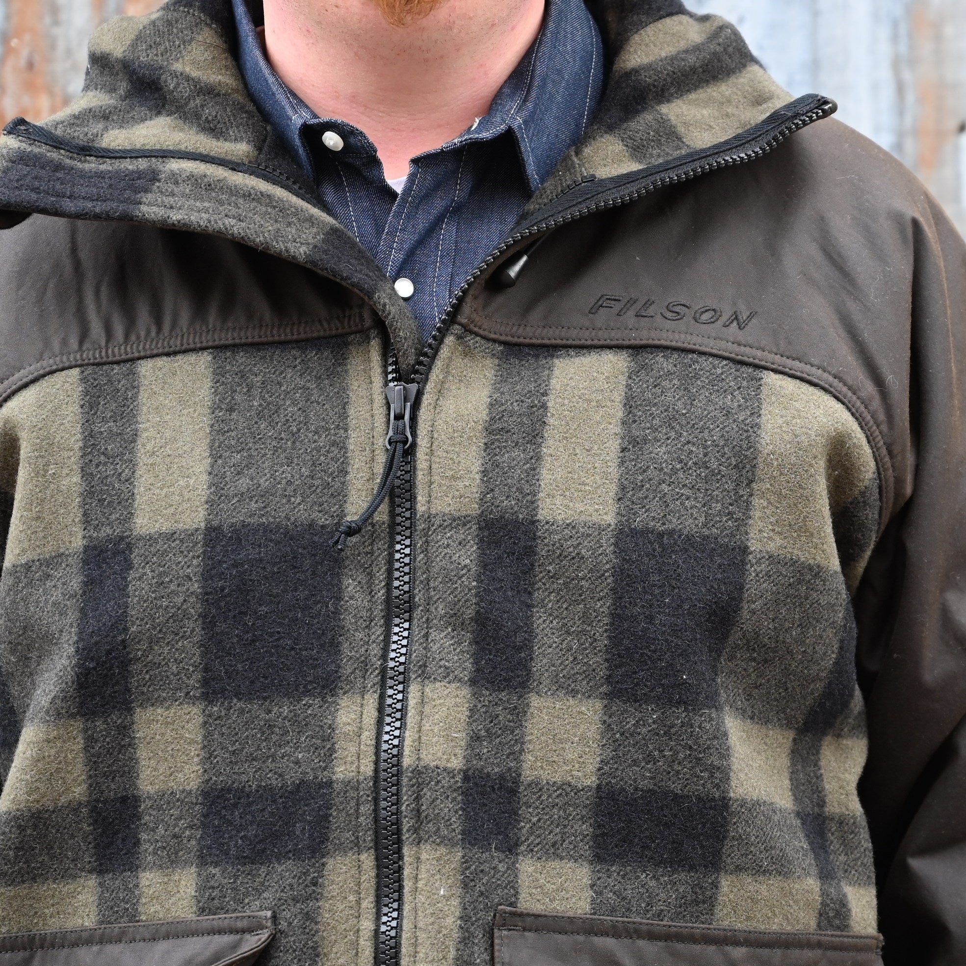 View of Filson Mackinaw Wool Hunting Jacket in Otter Green/Black Plaid featuring oil-finish Cover Cloth overlays and fleece-lined pockets