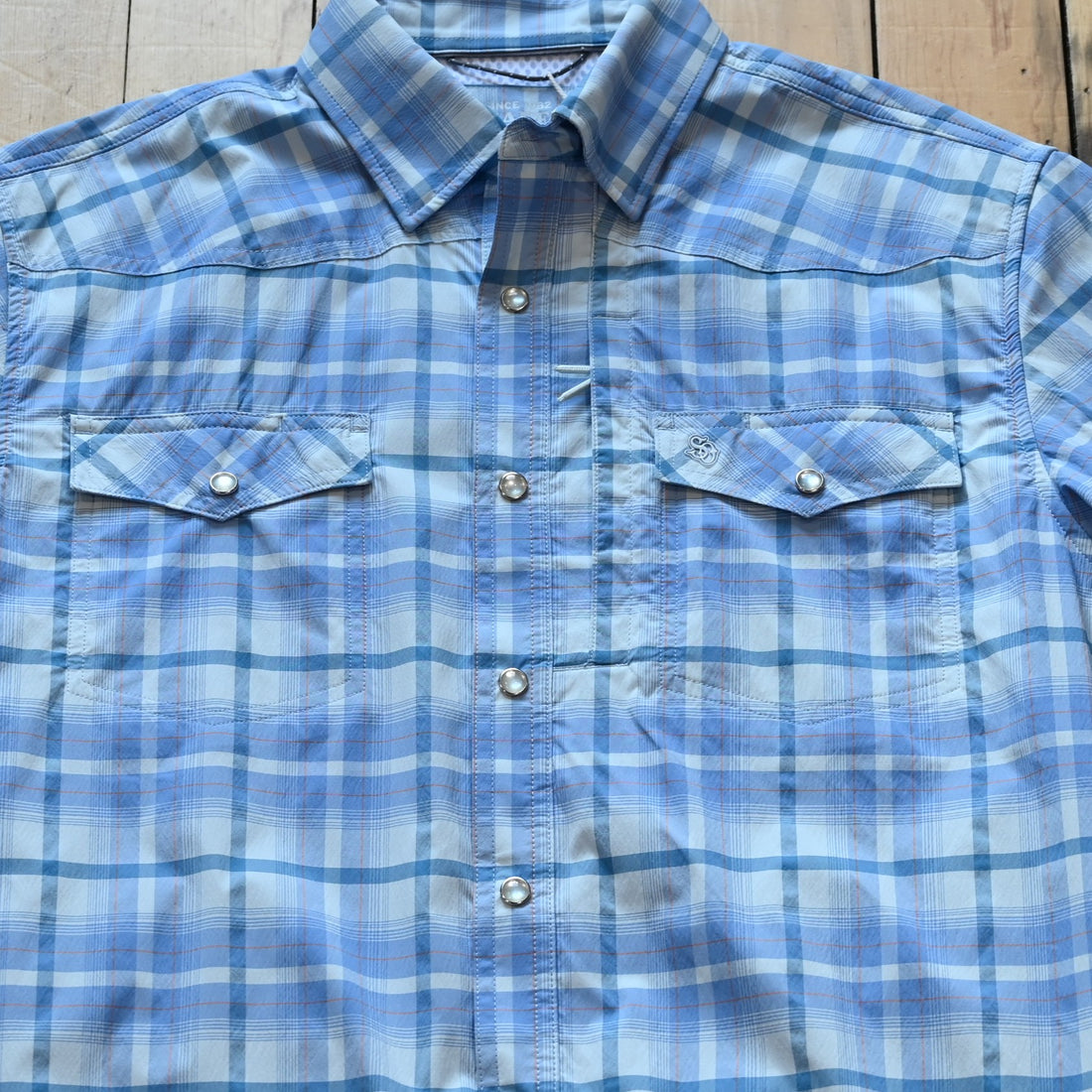 View of Short sleeve RangeTek Western snap shirt in soft blue with mesh back vent and snap pockets