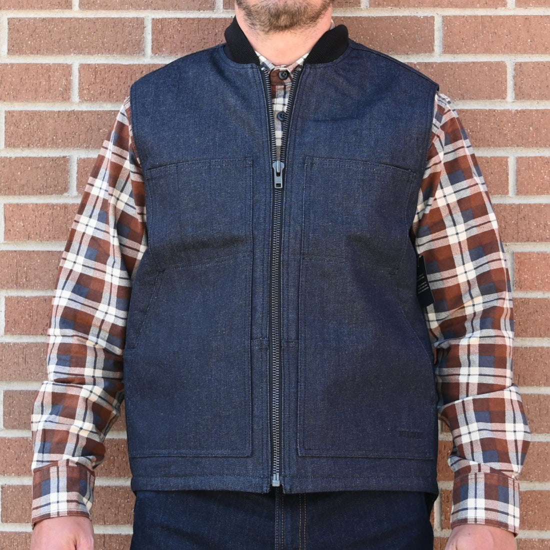 View of Filson Denim Insulated Work Vest in Raw Indigo featuring wool-blend rib-knit collar and four-pocket design