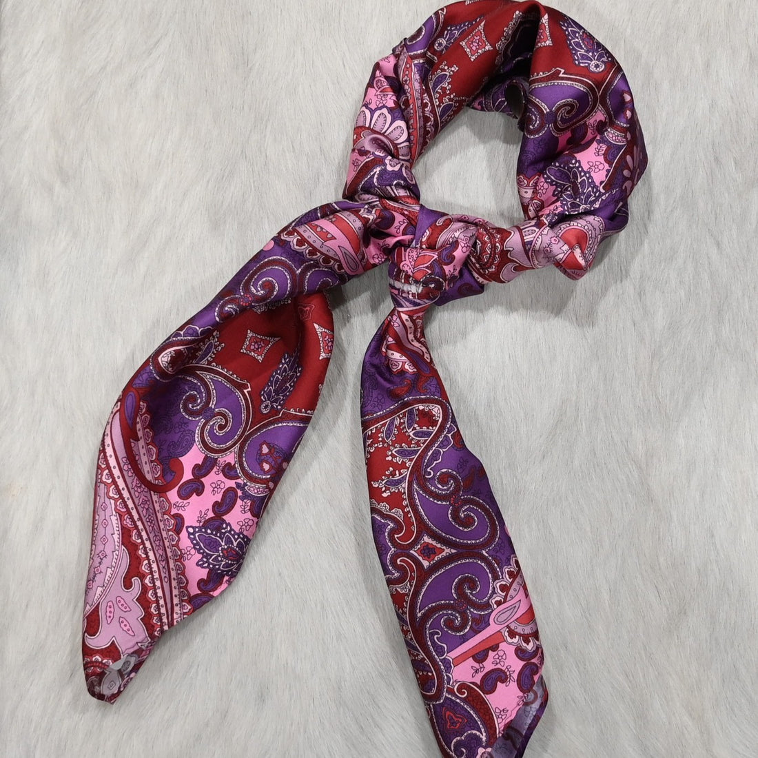 View of Purple and burgundy paisley silk wild rag with rolled edges