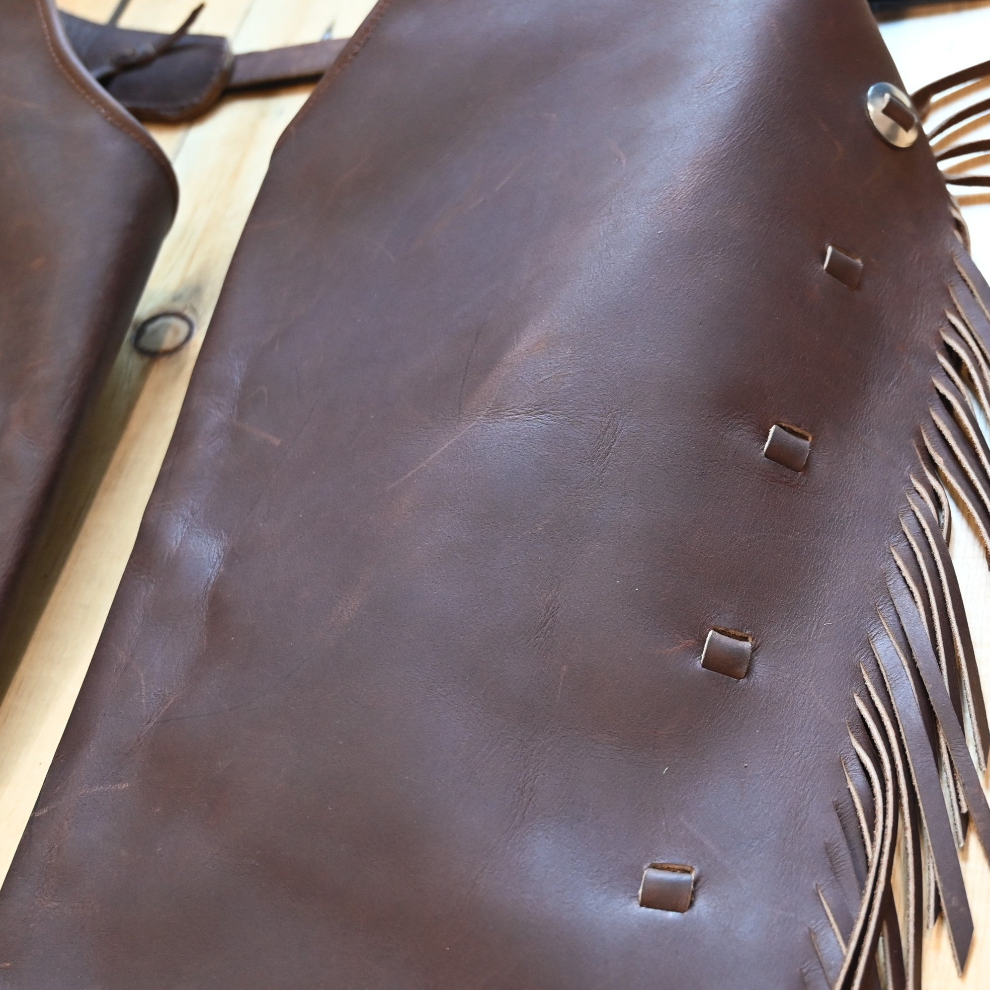 View of K Bar J Cowboy Basic Shotgun Chaps in Size Medium with fringe and buckle closures