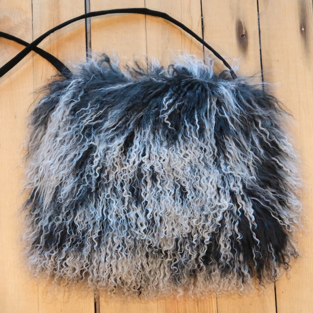 Close-up of wavy, long-haired Tibetan lamb fur on Morris Kaye luxury handbag.