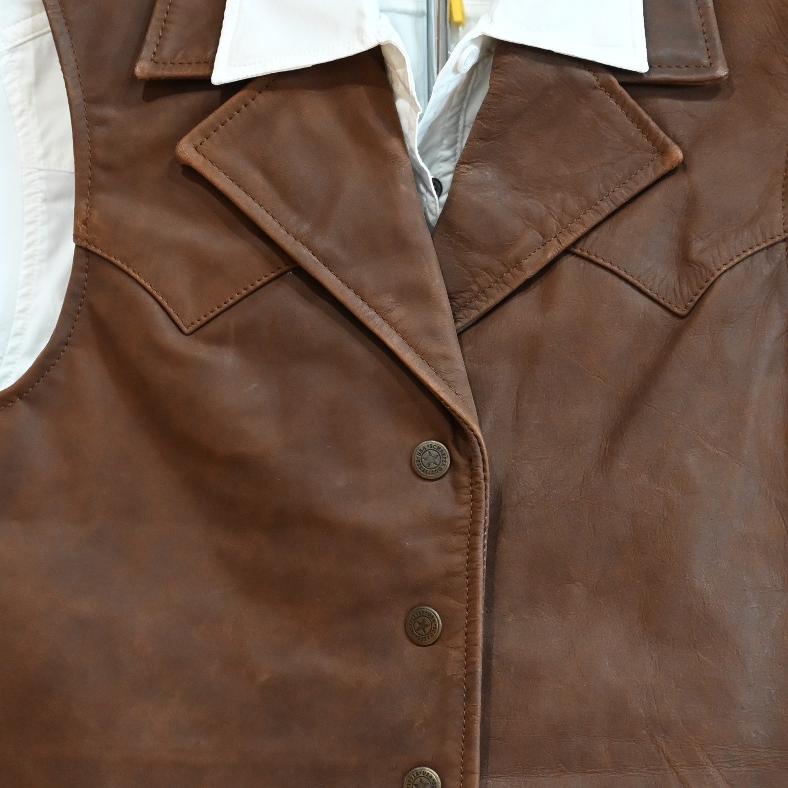 View of Schaefer ladies whiskey leather vest with Western yoke, snap front, and interior pockets