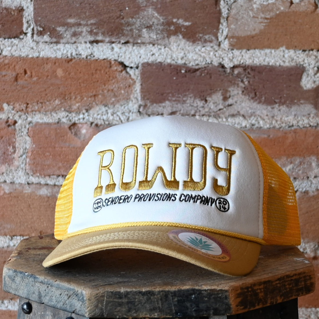 Sendero Rowdy foam-trucker hat with embroidered “Rowdy” design, rope-accented visor, and snapback closure.