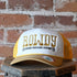 Sendero Rowdy foam-trucker hat with embroidered “Rowdy” design, rope-accented visor, and snapback closure.
