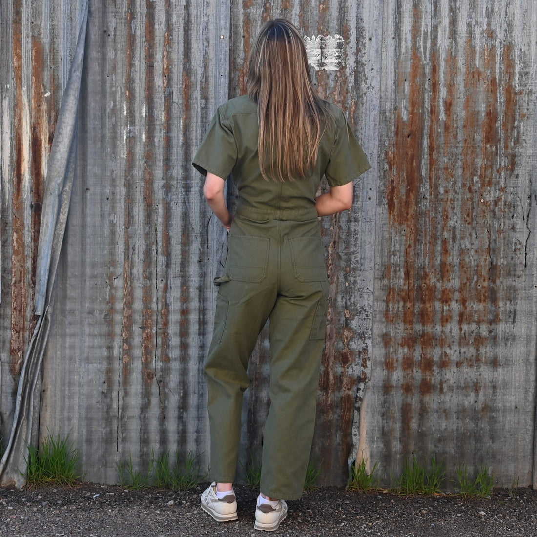 View of Filson Ladies Field Short Sleeve Coverall in Army Green featuring double-layer leg fronts, tool pockets, and hammer loop
