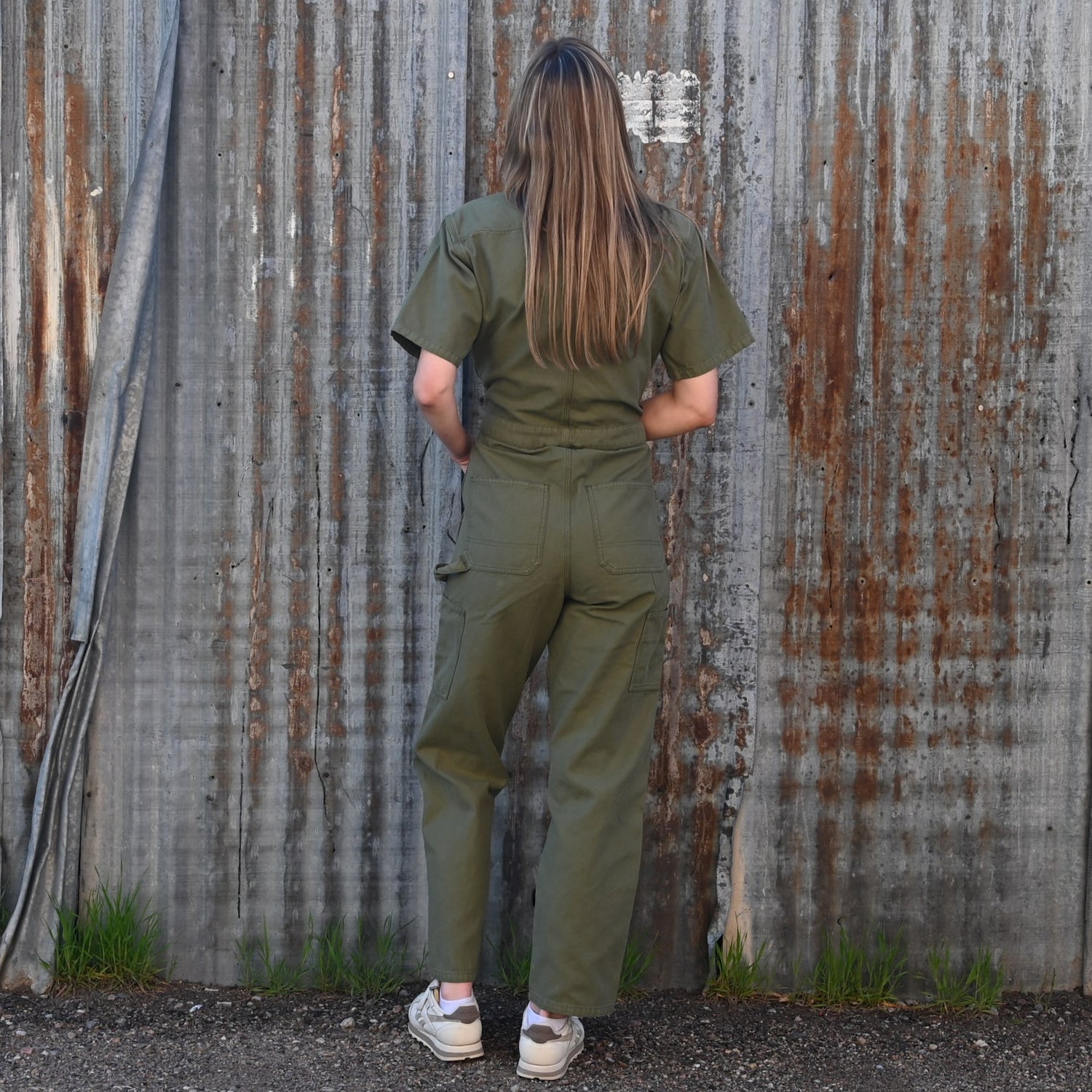View of Filson Ladies Field Short Sleeve Coverall in Army Green featuring double-layer leg fronts, tool pockets, and hammer loop