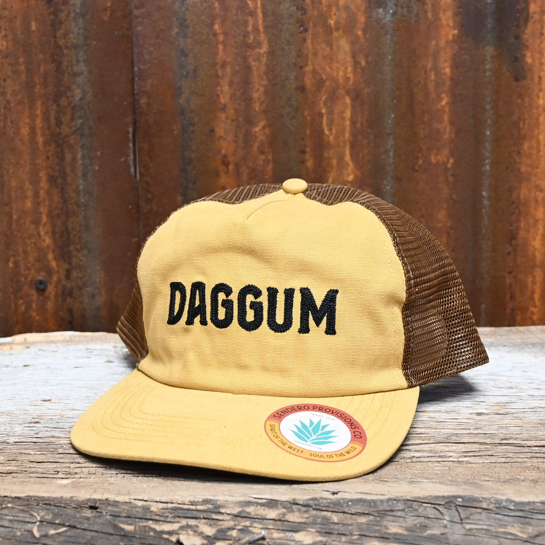 View of Sendero “Daggum” Hat with yellow-gold front, brown mesh back, and brown embroidery