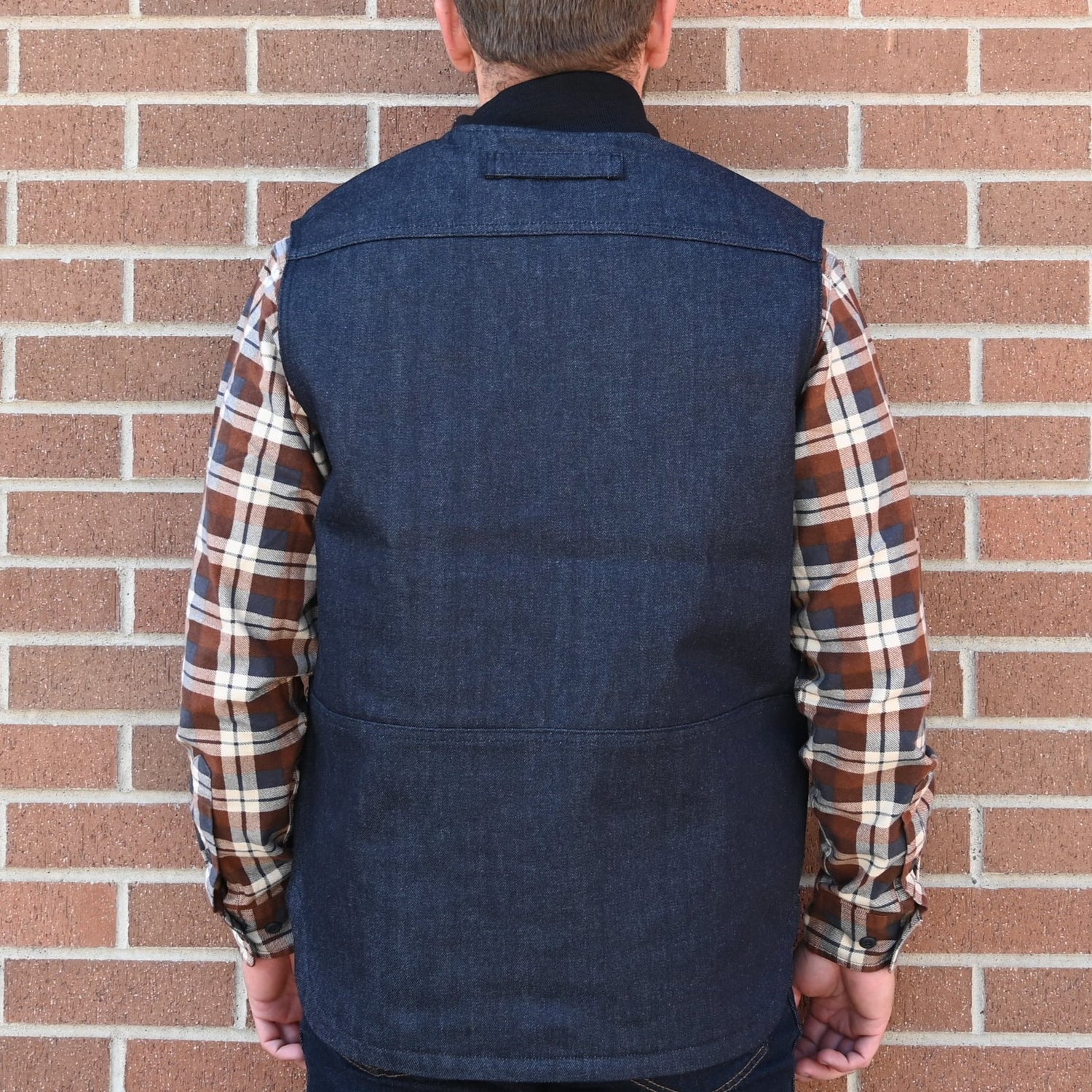 View of Filson Denim Insulated Work Vest in Raw Indigo featuring wool-blend rib-knit collar and four-pocket design