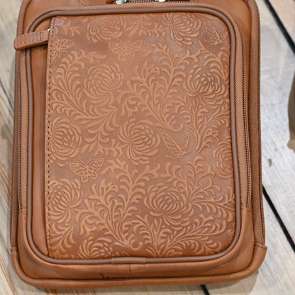 Tan leather crossbody shoulder pouch with embossed front, designed for concealed carry