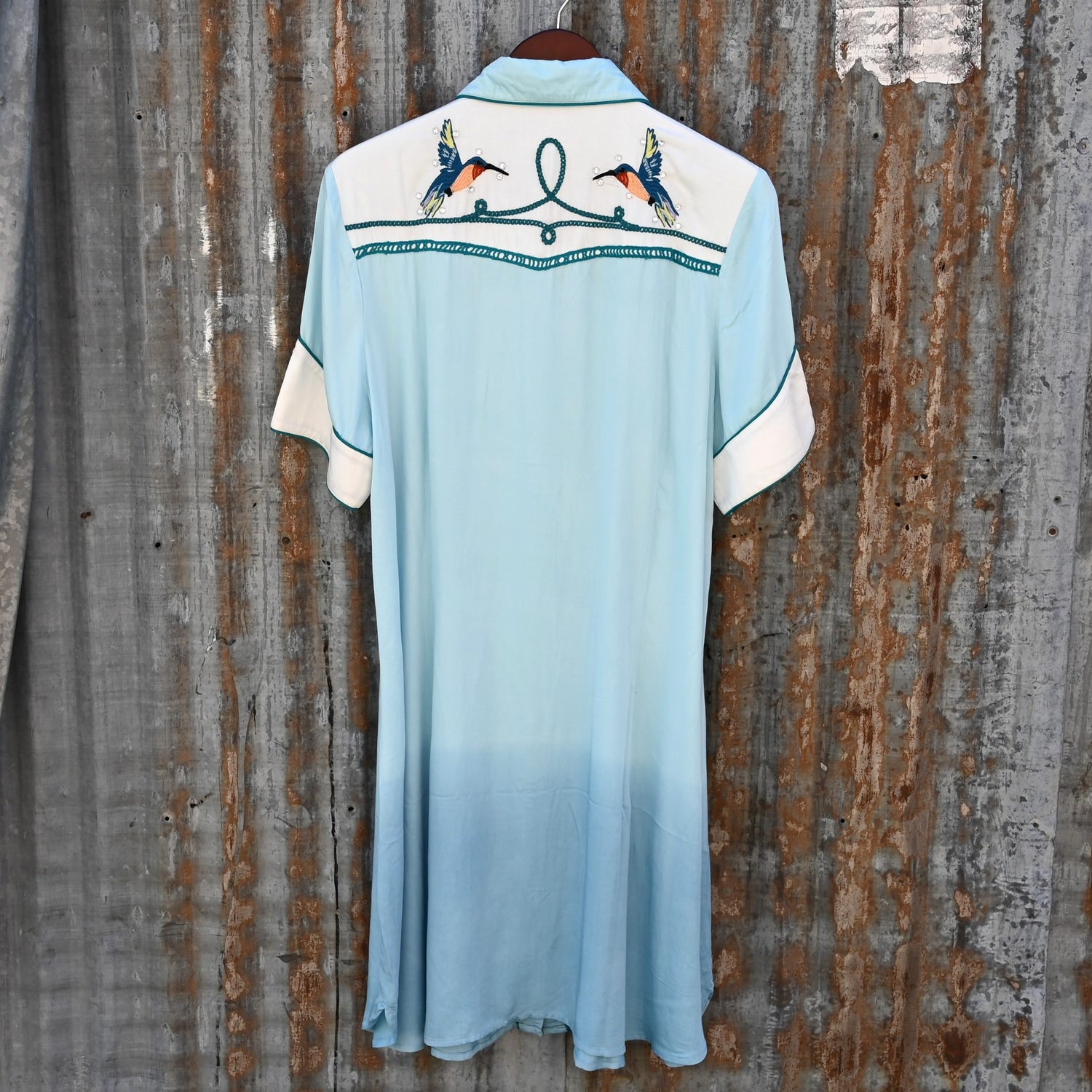 View of Double D Ranch Senoritas Rodeo Dress in Celestial Sky featuring embroidered floral print, pearl snap button closure, and drawstring waist