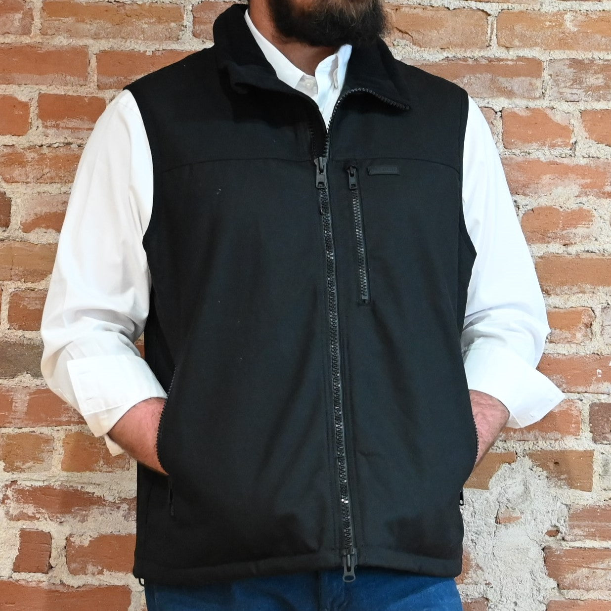 View of Filson Tin Cloth PrimaLoft® Vest in Black, Navy, and Dark Tan, showcasing durable waxed cotton exterior and fleece-lined interior