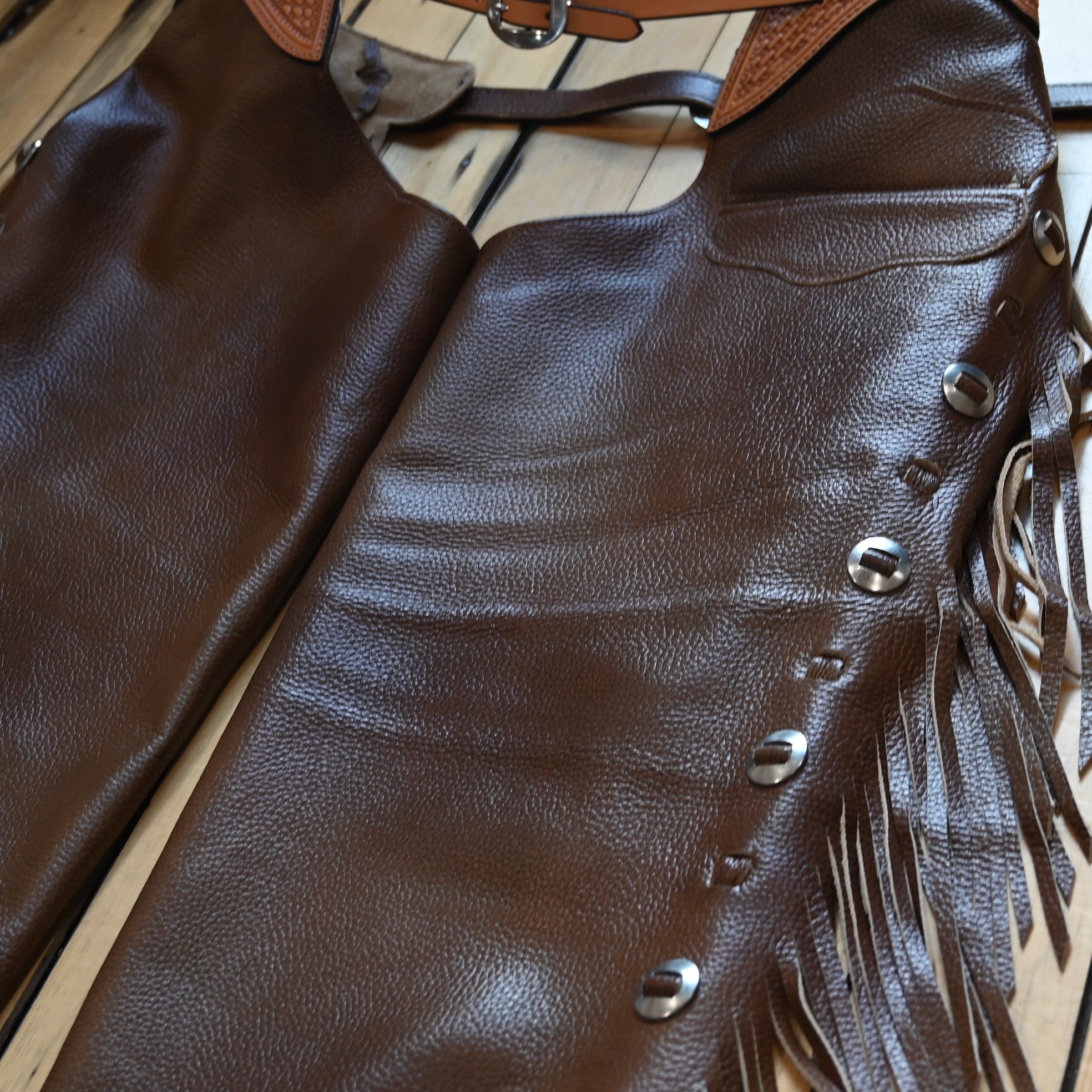 View of K Bar J Puncher Versatility Chap in Size Large with basket weave tooling and slotted conchos