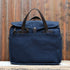View of Filson Original Briefcase in Navy, showcasing rugged twill fabric and bridle leather accents