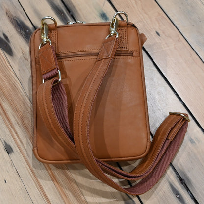 Tan leather crossbody shoulder pouch with embossed front, designed for concealed carry
