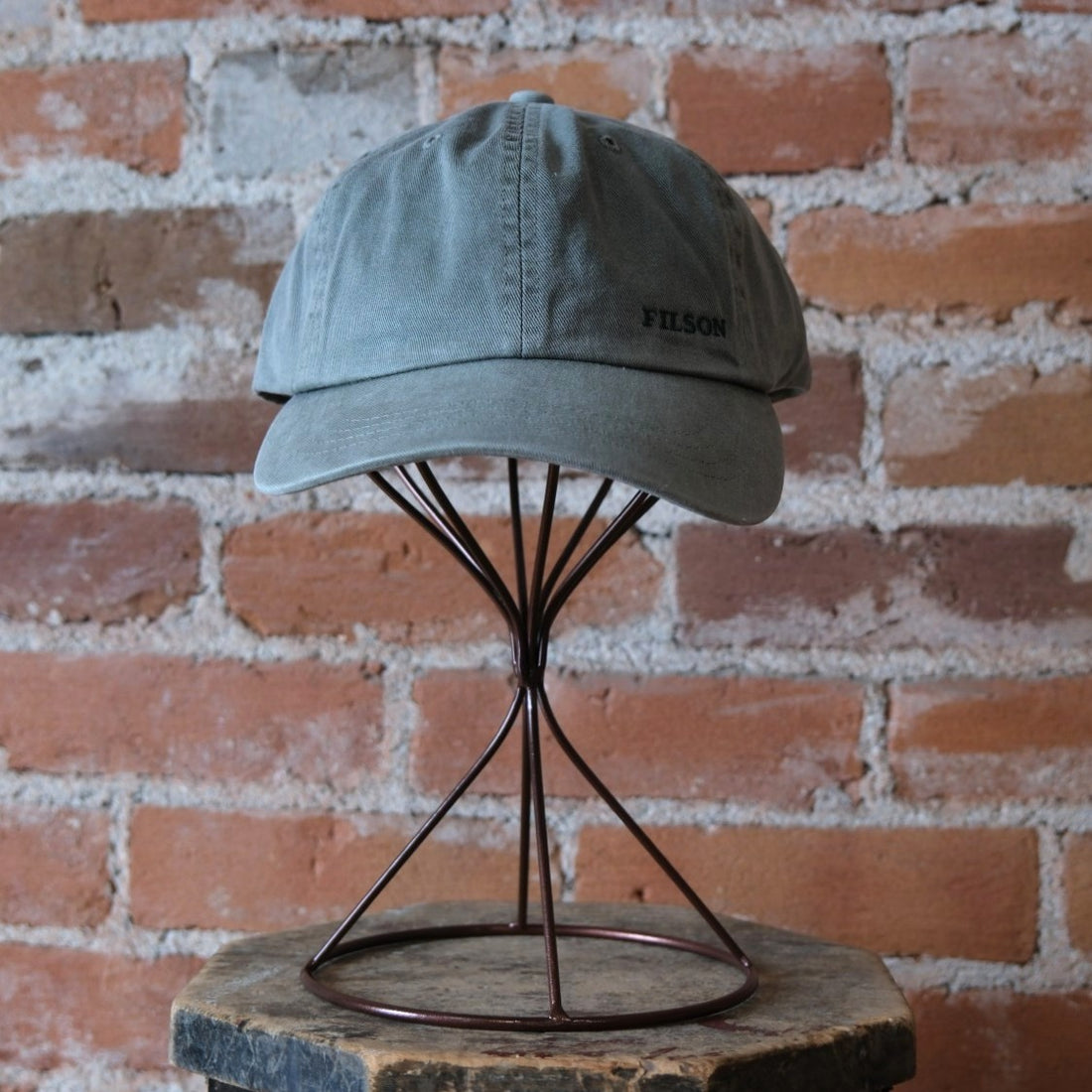 Filson Washed Low-Profile Logger Cap in Washed Olive featuring a 6-panel design and embroidered Filson logo.