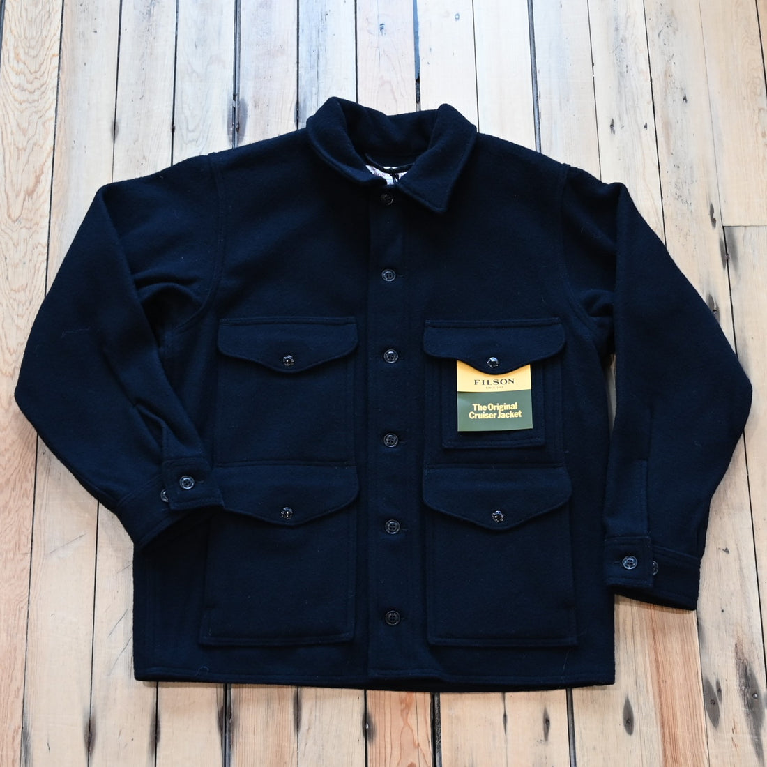 View of Filson Mackinaw Cruiser in Navy, Charcoal &amp; Natural/Black Heritage Plaid featuring button-secure front closure, adjustable cuffs, and multiple pockets