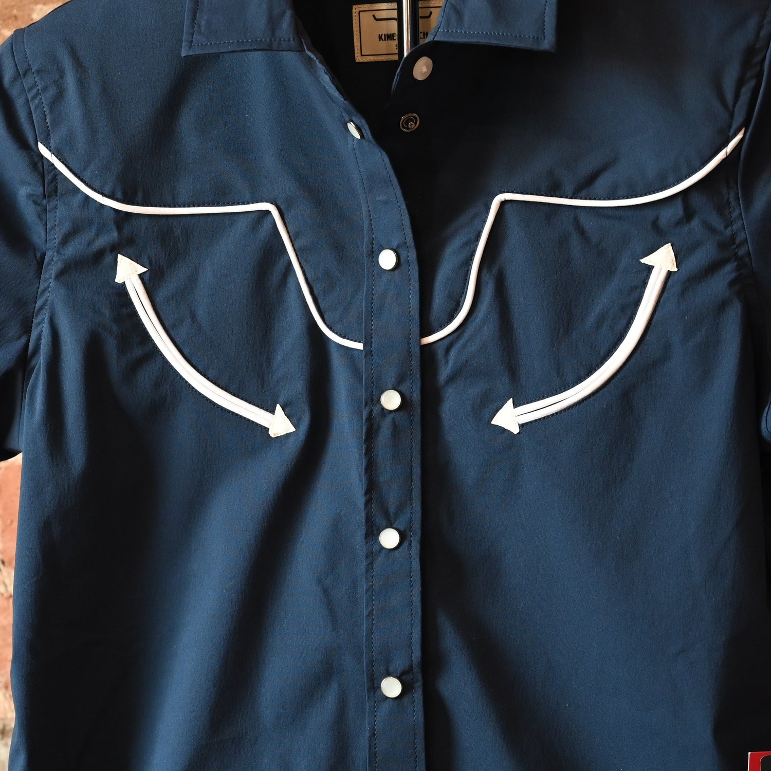 View of Kimes Ranch Long Horn Top in Navy, featuring a short-sleeve design, vintage arrow accents, and a subtle longhorn logo