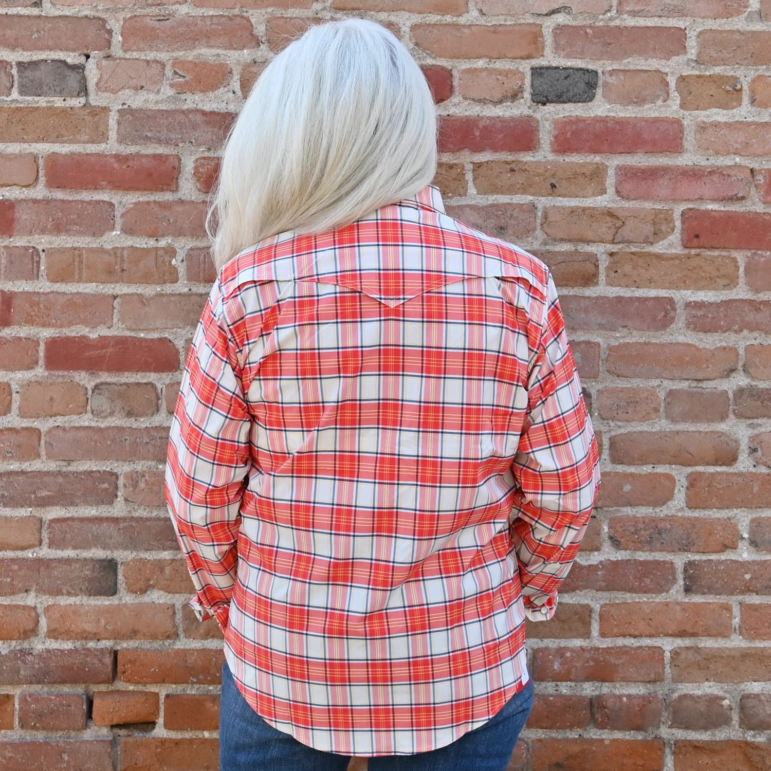 View of Schaefer coral plaid Range Tek shirt with snap front, mesh venting, and yellow and navy accents