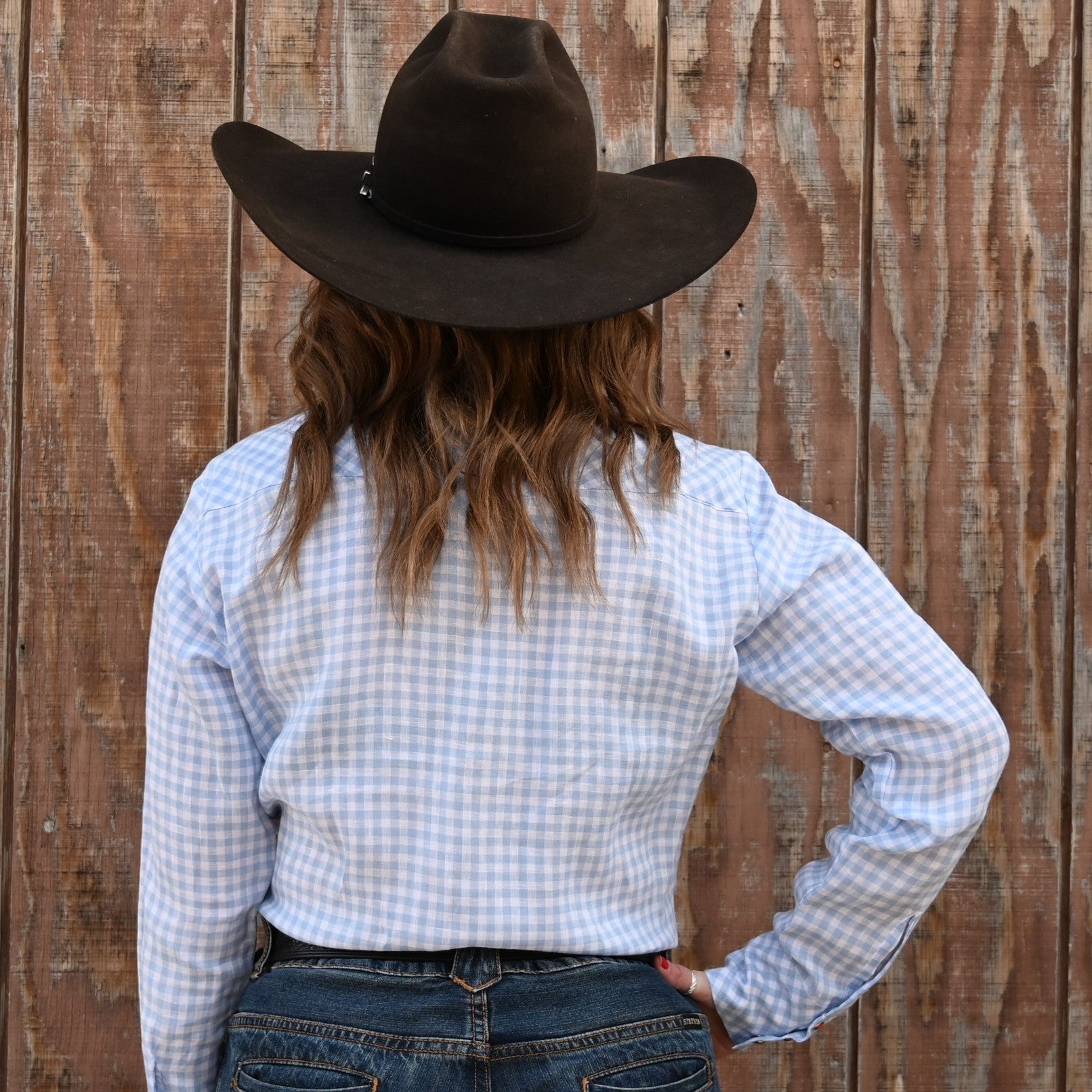 View of Blue Blanket ladies light blue linen Western shirt with orange pearl snaps and plaid pattern