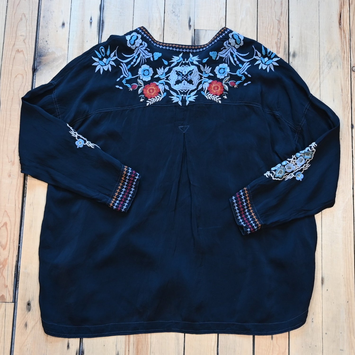 View of Johnny Was sanded black blouse with tonal embroidery on front and shoulders