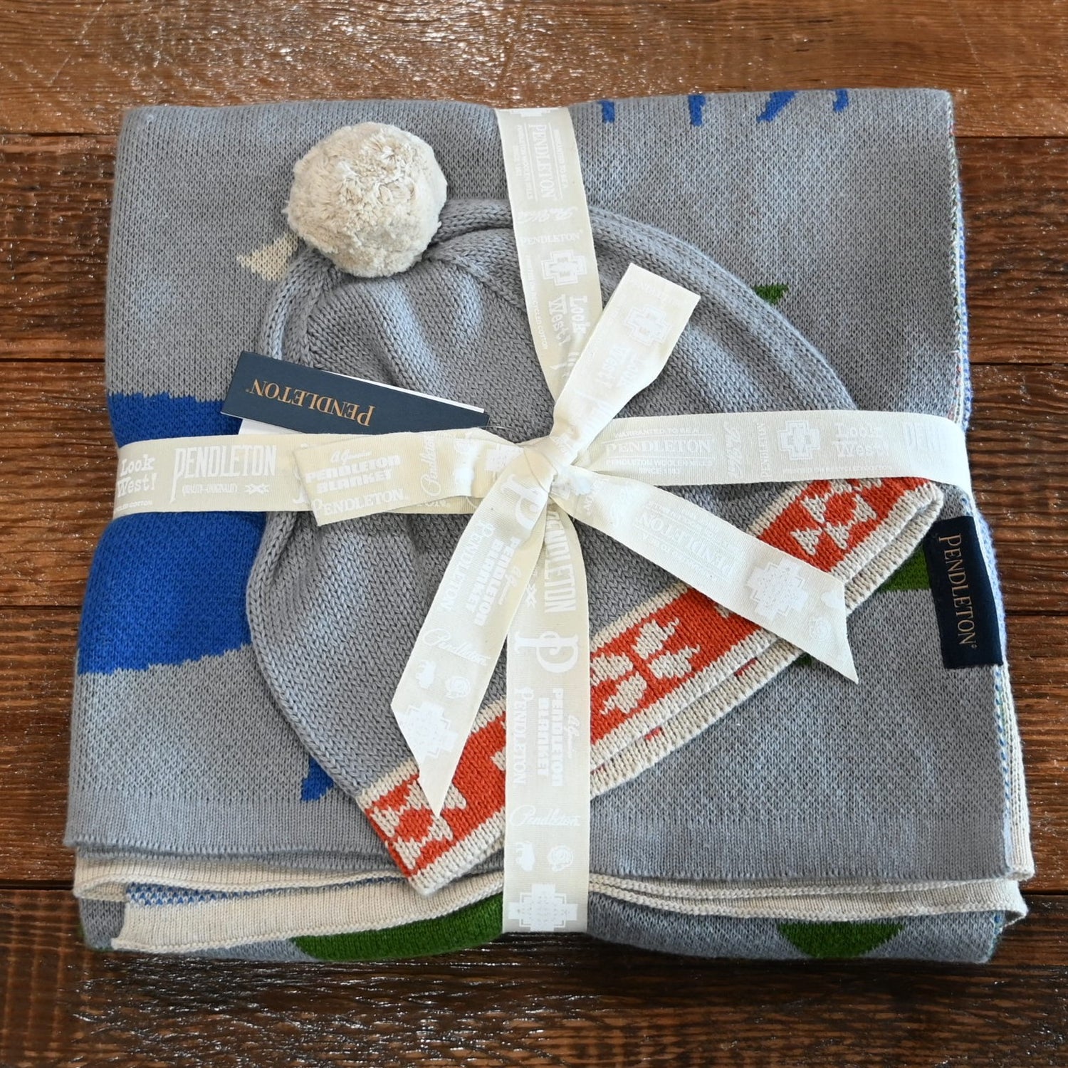 View of Pendleton Shared Paths baby blanket and beanie in Grey Mix with wildlife print