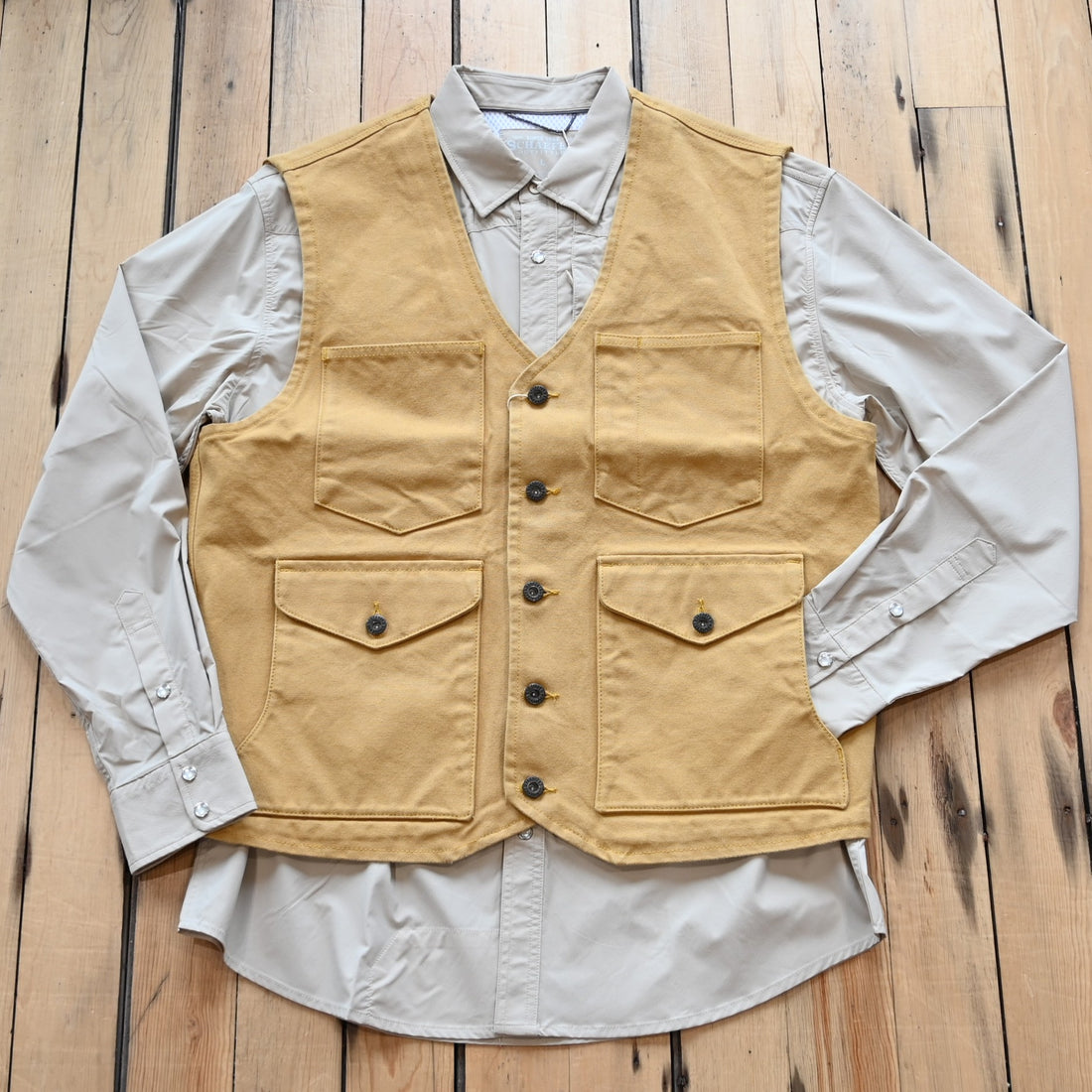 View of Schaefer brushcloth vest in suntan canvas with utility pockets and brass buttons
