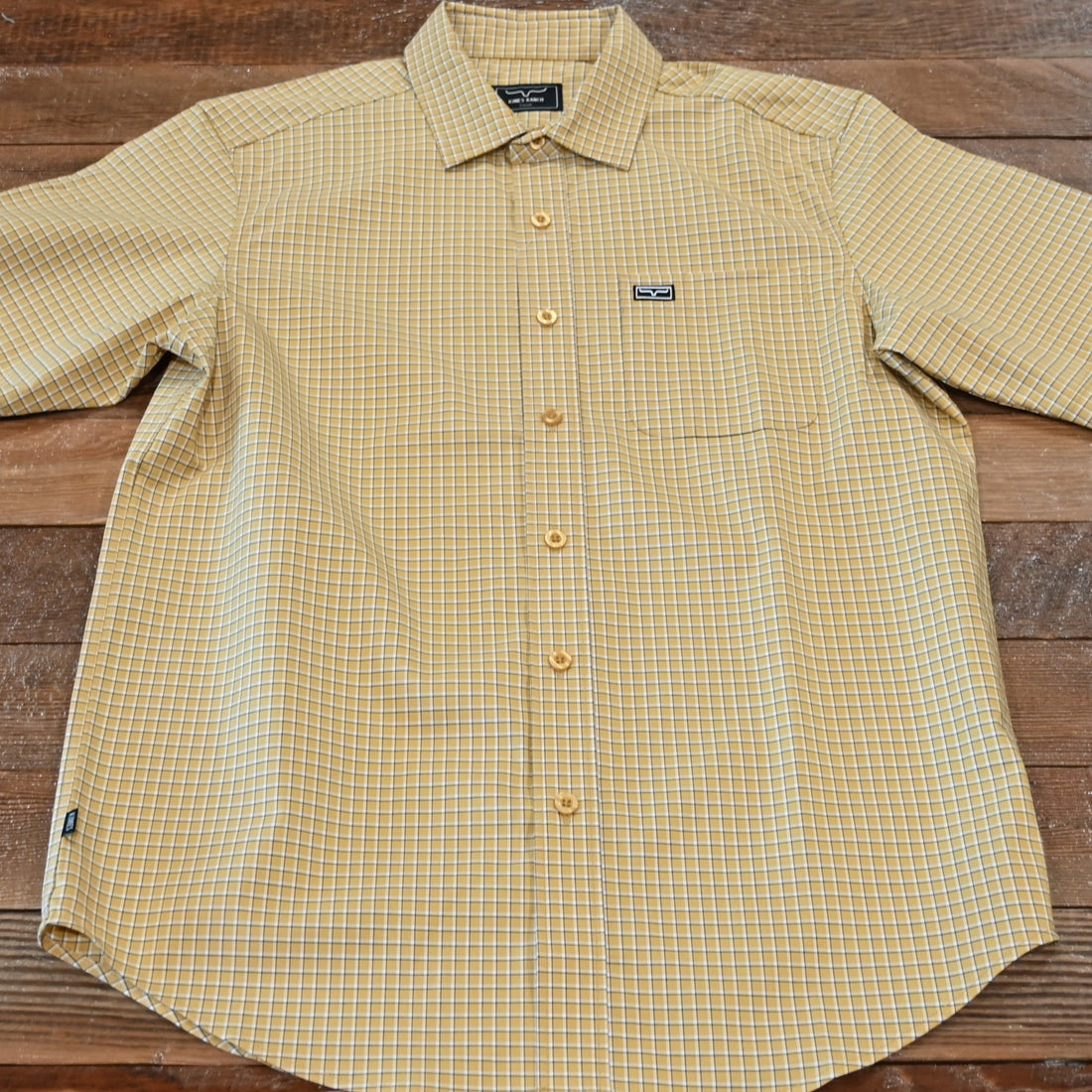 View of Kimes Ranch MC Cooper Short Sleeve Button-Up Shirt in Gold, featuring a grid plaid pattern and snap button front